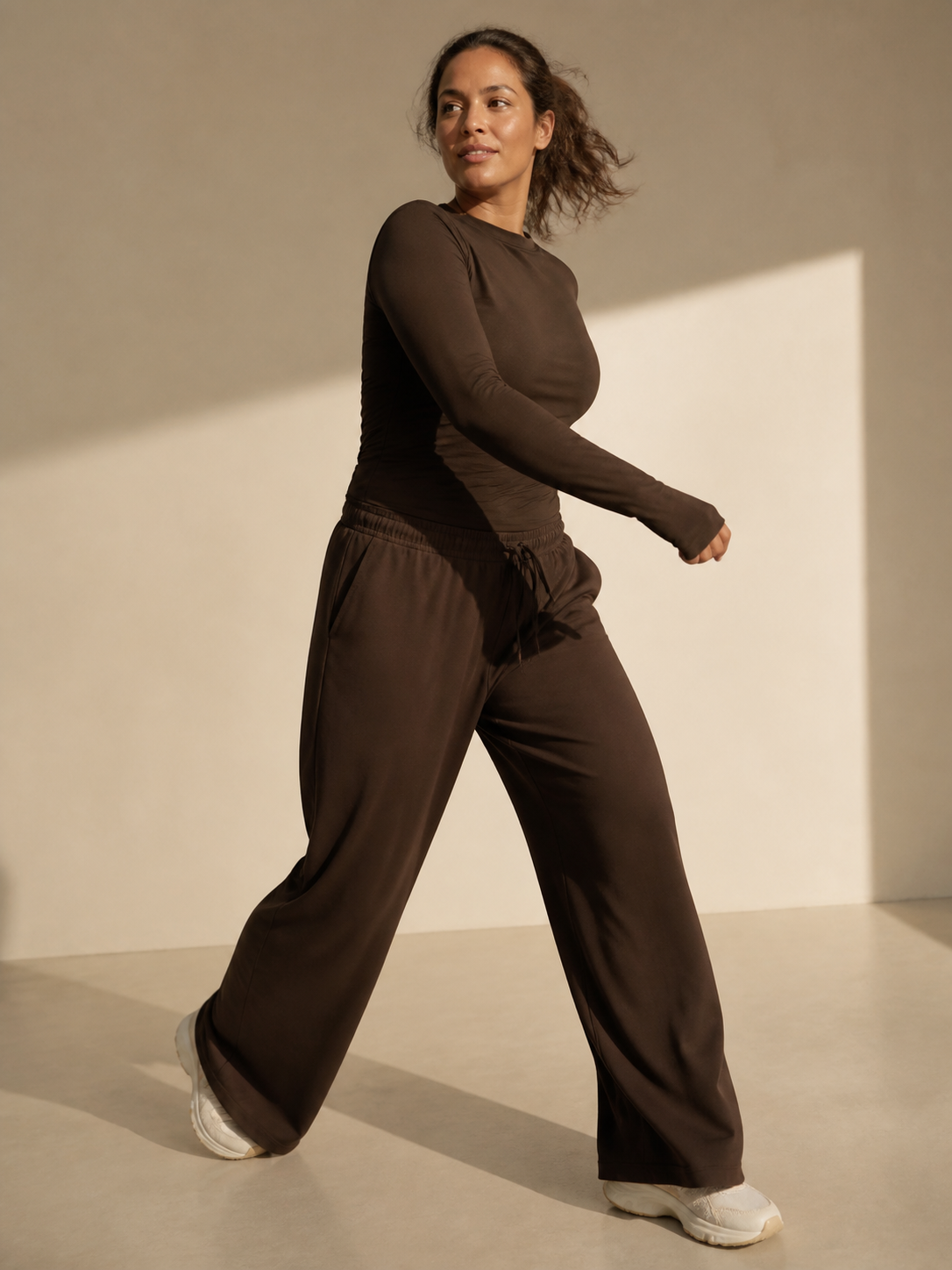 Woman moving in brown wide-leg athleisure trousers